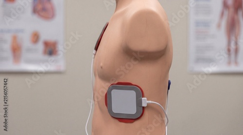 Fototapeta kuchenna A defibrillator pad is positioned on the side of a CPR training mannequin. The image demonstrates AED electrode placement for emergency response education.