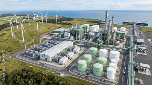 Aerial view of a wind farm and industrial processing plant by the sea