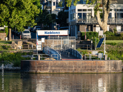 Obraz na płótnie Koblenz, Germany - June 12, 2022: View across the Moselle River of the passenger ferry landing pier with a Koblenz sign and stone stairs along the riverbank in Koblenz