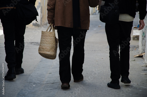 Foto Anonymous street view of men walking with a traditional woven basket
