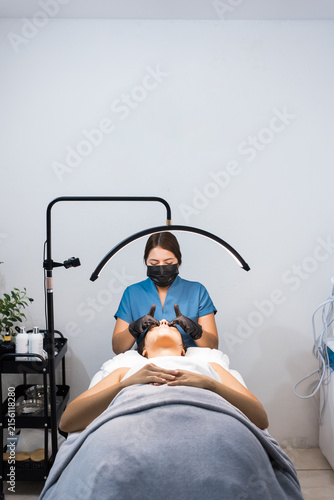 Fotografía Esthetician performing a precise facial treatment on a client in a spa