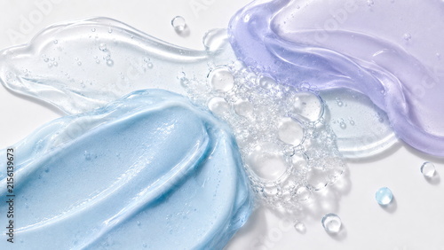 Luxury skincare cosmetic textures in translucent icy-blue and pale-lavender gels with glossy surfaces and delicate air bubbles on a clean white background.