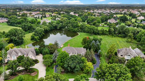 Quadro su tela Tree-filled suburban neighborhood surrounding a landscaped pond in summer aerial