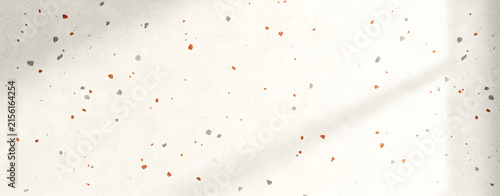 Elegant terrazzo stone texture with white background, subtle grey shadows, and colorful speckled chips for interior design and architecture background