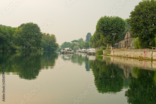 Принти на полотні La Charente à Jarnac offre un décor paisible où le fleuve méandre doucement, bordé de quais historiques, de chais réputés et de parcs verdoyants invitant à la flânerie et aux loisirs nautiques