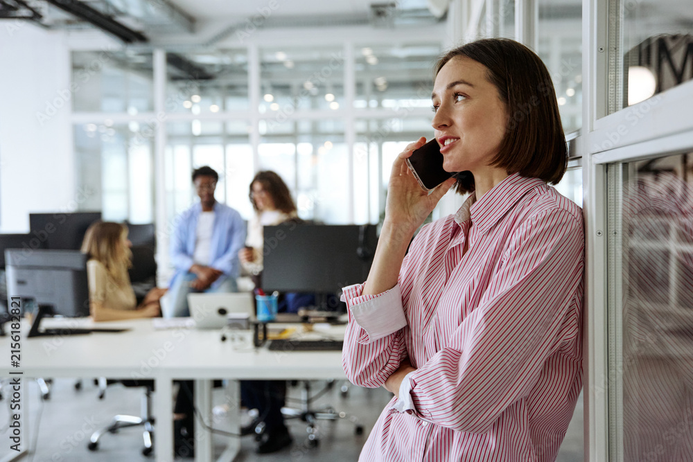 Obraz premium Diverse business team talking phone during a collaborative office meeting