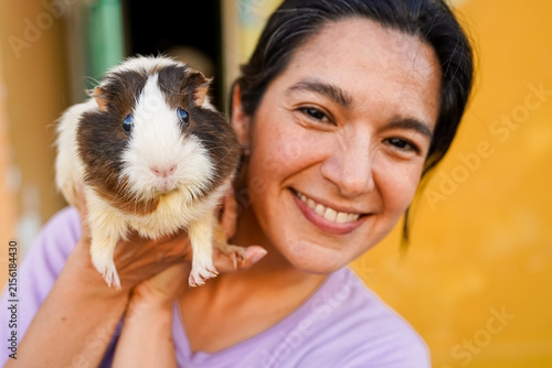 Smiling woman holding guinea pig showing pet love