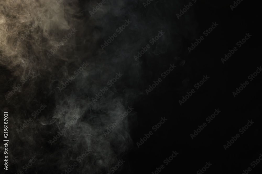 Fototapeta premium Beautiful smoke in light on dark background, space for text