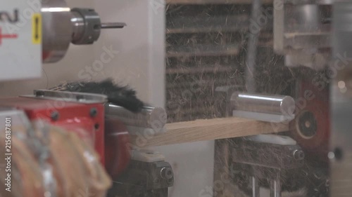 CNC woodworking machine milling a precision edge profile on a wooden board slow motion. Automated routing process creates an interlocking joint for furniture manufacturing and wood assembly.