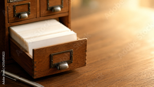 Vintage Wooden Card Catalog Drawer Filled with White Index Cards on Desk in Library Archive