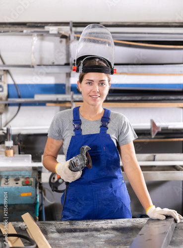 Quadro su tela Female worker cutting aluminum profile for windows using angle grinder