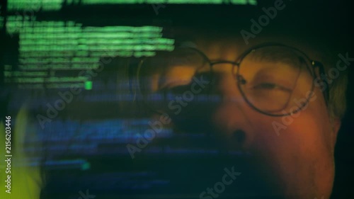 Programmer Typing Code With Face Reflected in Computer Screen