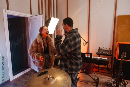 Fotografie Two young musicians talking loudly in a creative music studio