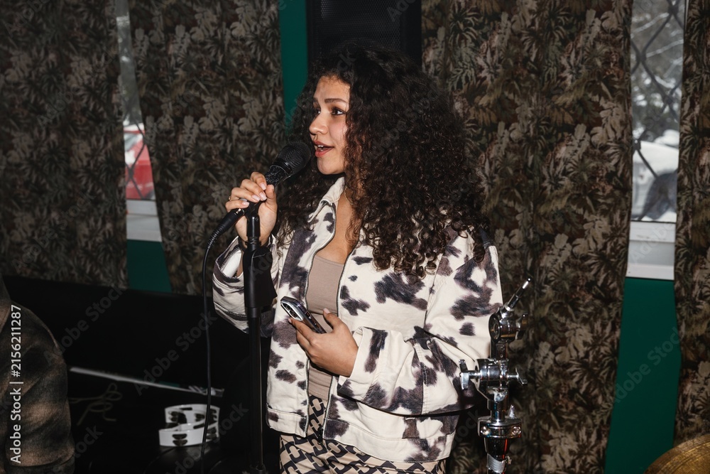 Obraz premium Young musician holding microphone in a creative music studio