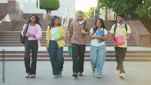 Group of happy indian students walking together on campus