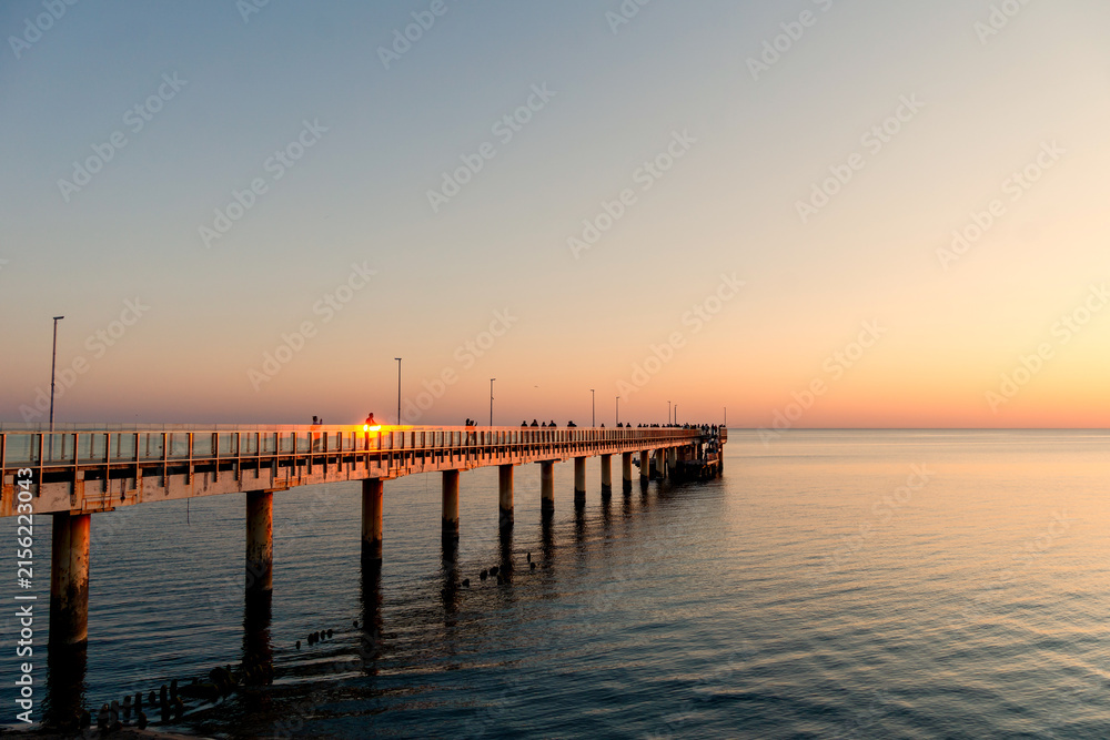Fototapeta premium People watching sunset from sea pier