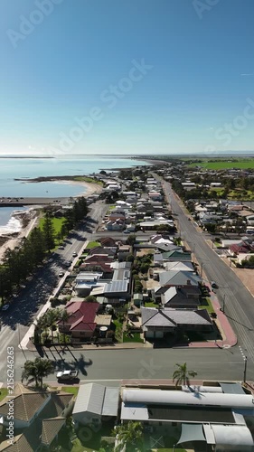 Port Broughton, Yorke Peninsula, South Australia – 4K aerial drone view of foreshore, jetty, beach, seaside township, residential houses, Norfolk pines, Spencer Gulf coastline and farmland