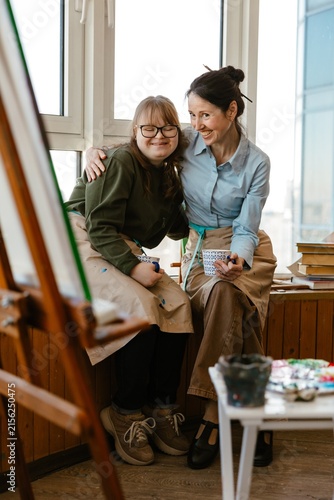 Photography Two female artists smiling together in a colorful art studio
