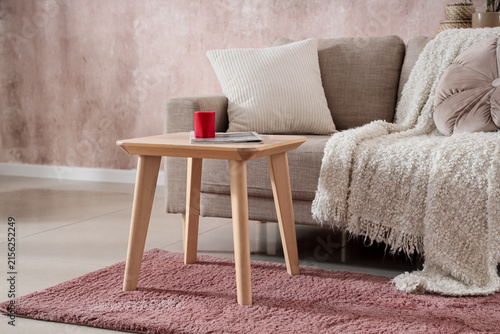 Portable sound speaker with magazine on table in living room interior
