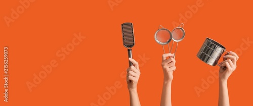 Photography Hands holding kitchen utensils including a grater, two strainers, and a flour si