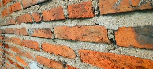 Close-up view of a rough red brick wall.