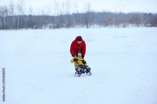 фотографія Grandfather and grandson sleigh riding during a winter outdoor adventure