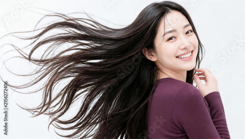 日本人女性の超ロングウェーブヘアがなびく笑顔の振り向き姿