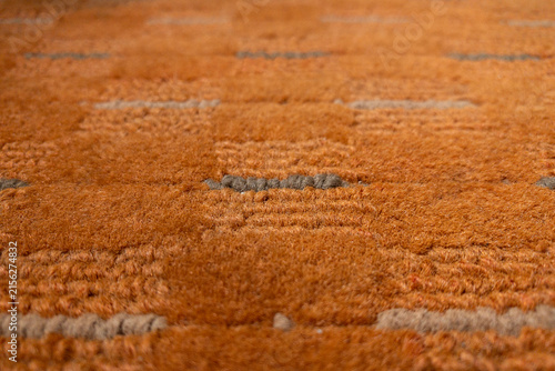 Fotografie Close-up of an orange shag rug showing soft, plush texture and subtle tufted pattern