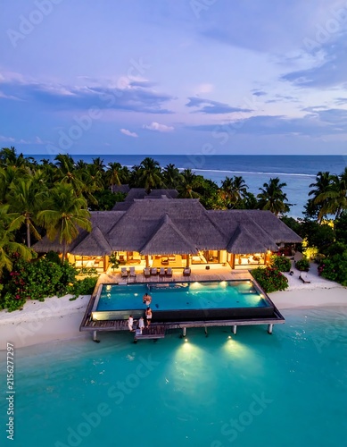 Luxury yacht anchored in calm tropical bay at sunset.