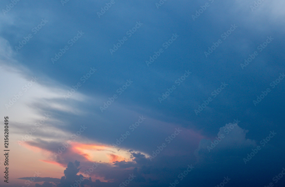 Obraz premium A cloudy sky with orange and blue hues at dusk