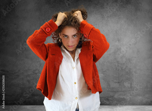 Beautiful young woman in an emotional pose against a neutral background.