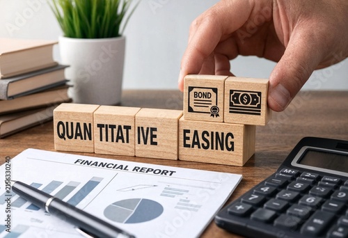Hand placing bond block on quantitative easing financial building blocks with calculator and financial report