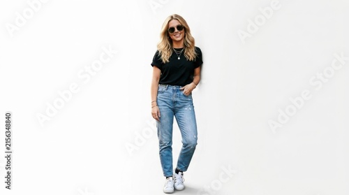 Smiling young woman wearing a black t-shirt and blue jeans posing casually while standing and looking at the camera