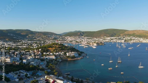 Bodrum, Turkey. Aerial view of the 15th-century Castle of St. Peter rising from a rocky promontory, its stone walls and towers commanding the marina and turquoise Aegean waters at golden hour. Aerial