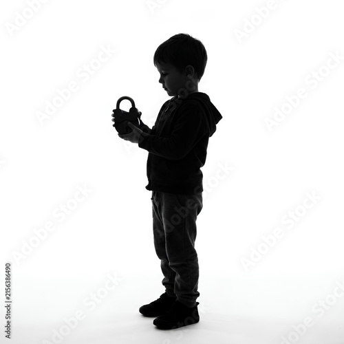 Silhouette of Child Holding Object in Hand.