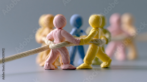 Small Clay Figures Playing Tug Of War Pulling Thick Rope
