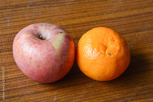 Fresh apples and oranges arranged on a rustic wooden table, showcasing vibrant colors and natural textures