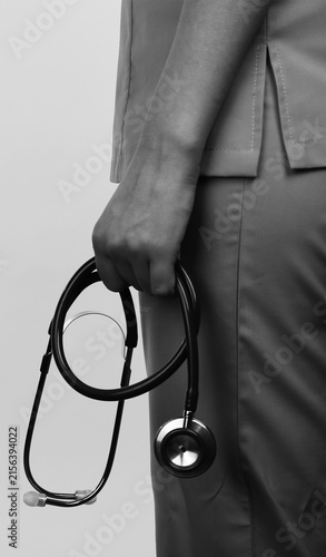 Doctor Holding Stethoscope by Side on Gray Background