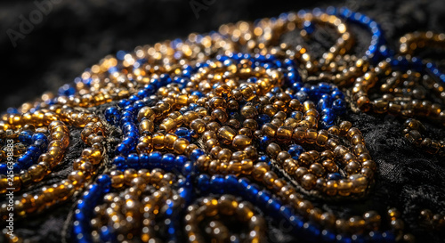 Close-up shot of intricate blue and gold beaded embroidery details