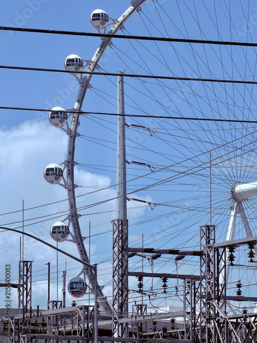 Photography Las Vegas observation wheel framed by railway power lines and electrical infrast