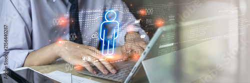 Digital identity and business technology concept featuring a professional using a laptop with a glowing human icon and connected digital interface. Represents user data, connectivity