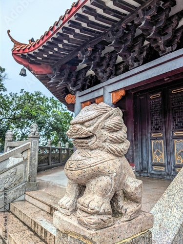 Konstfotografi Stone lion statue guarding traditional temple entrance