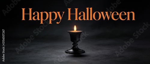 Happy Halloween text with a single lit candle in a dark room.