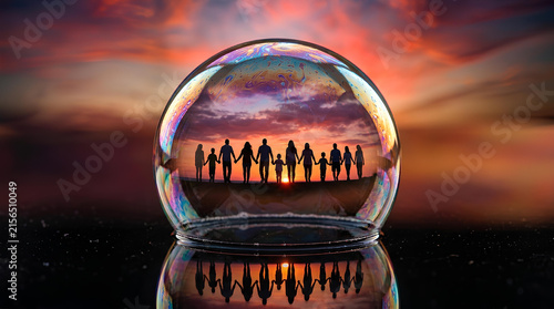 Silhouette of people holding hands inside a crystal ball.