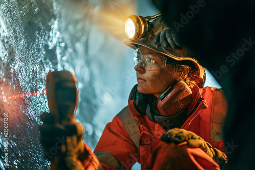 Coal miner wearing a headlamp working inside a dark mine