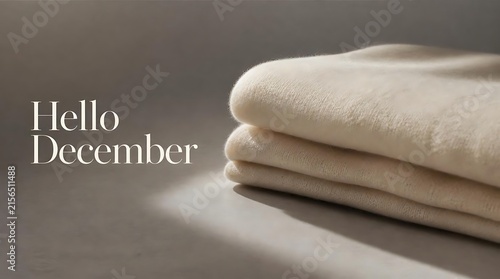 Cozy Hello December text with folded blankets and soft light.