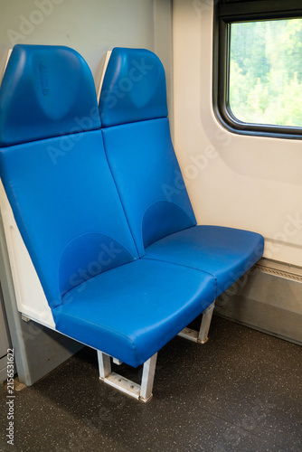 Fotografie Two empty blue seats in a commuter train car near the window