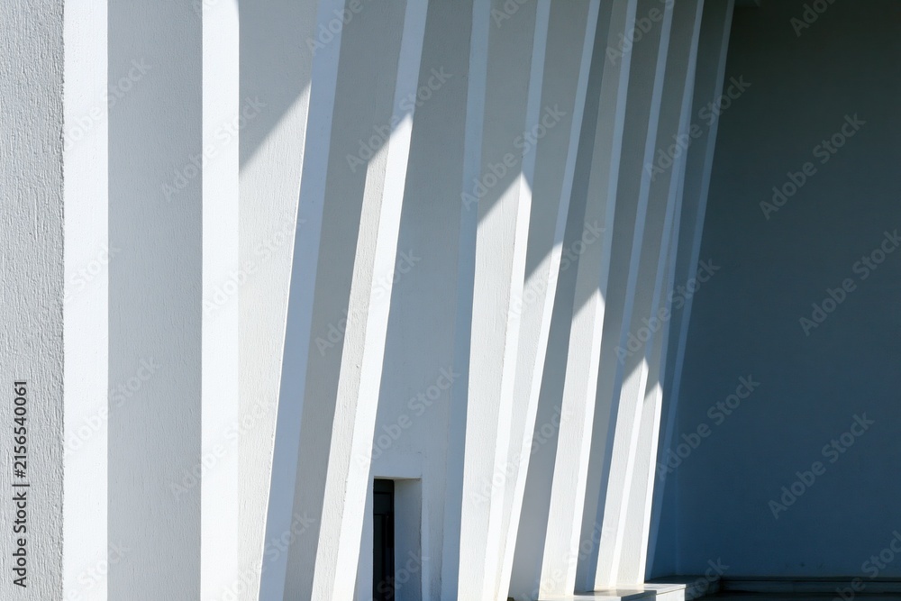 Fototapeta premium Modern White Building Exterior with Strong Geometric Shadows and Architectural Lines