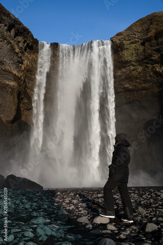 Cuadro en lienzo Back View of Man Looking Up at Skógafoss Waterfall in Iceland