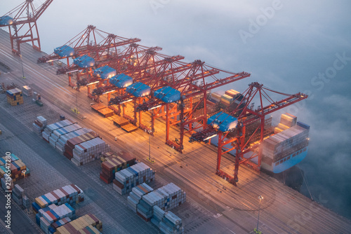 Cranes loading containers onto a cargo ship at a port in Long Beach
